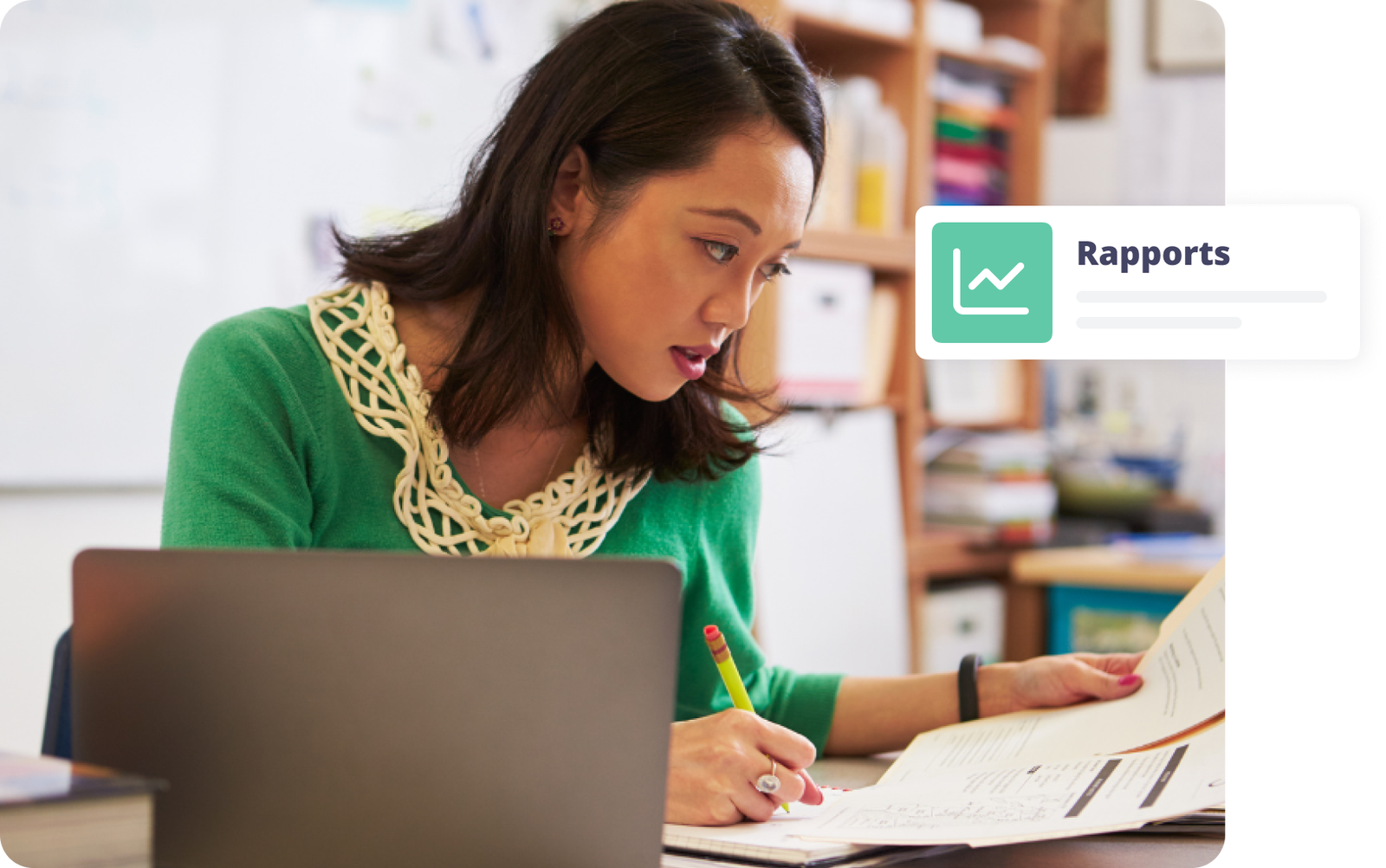 Femme absorbée par son travail, prenant des notes sur des rapports à son bureau.