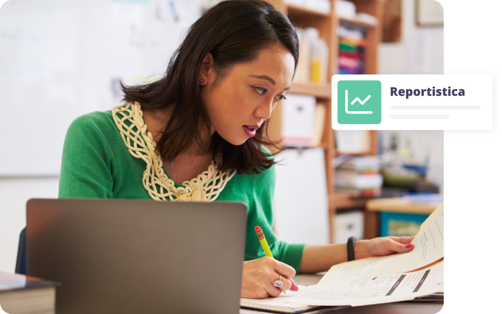 Donna che studia reportistica con appunti e computer in un ambiente di lavoro luminoso.