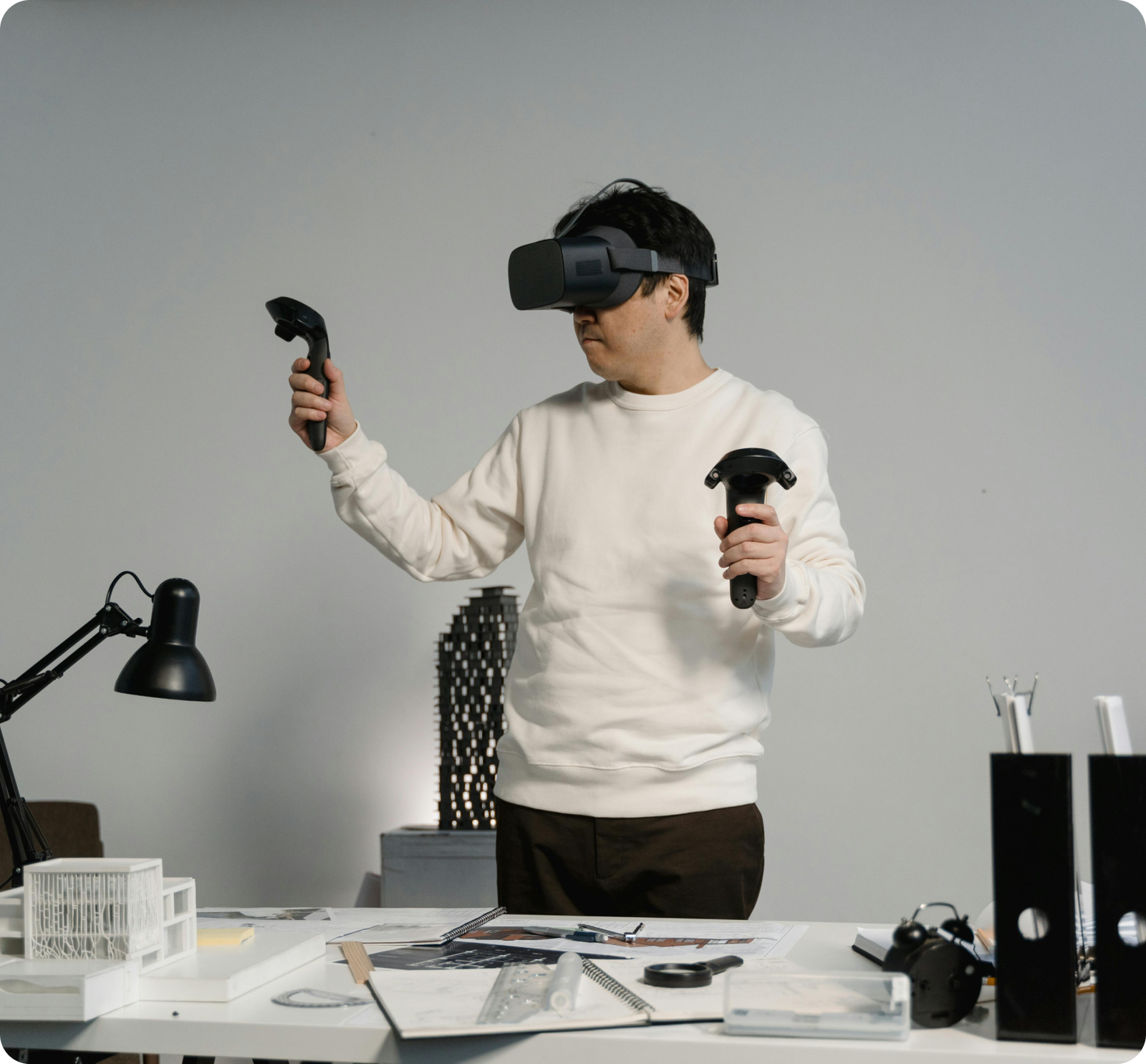 Person gaming with headset, computer, and VR headset.