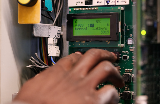 Hand interacting with an industrial control panel interface.