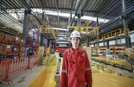 Factory worker walking through an industrial production line.