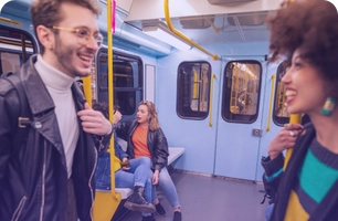 Young adults enjoying a lively conversation on a colorful subway train.