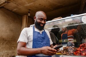A man in an apron looks at a smartphone
