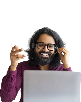 A smiling Indian woman with headphones in front of a computer