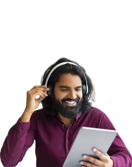 Indian man wearing wireless earphones using tablet.