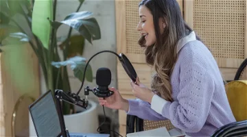 Woman using recording equipment to create a podcast voice over