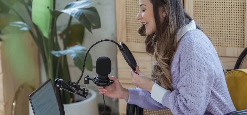 Woman using recording equipment to create a podcast voice over