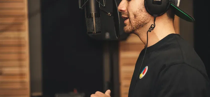 Un hombre graba su voz con un micrófono en un estudio.
