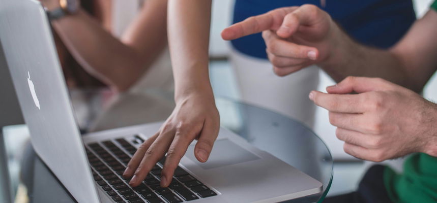 People pointing at a laptop screen.