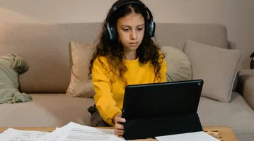 A student wearing headphones learning where ReadSpeaker fits in the landscape of assistive tech for education