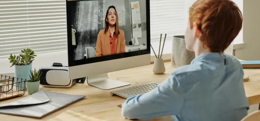 A child sitting by the table while looking at the iMac. What the European Accessibility Act means for e-learning