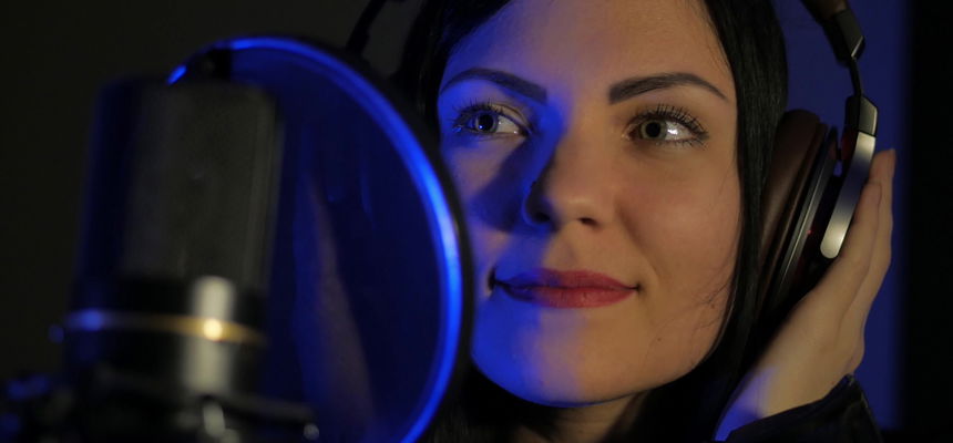 Woman with headphones in recording studio.