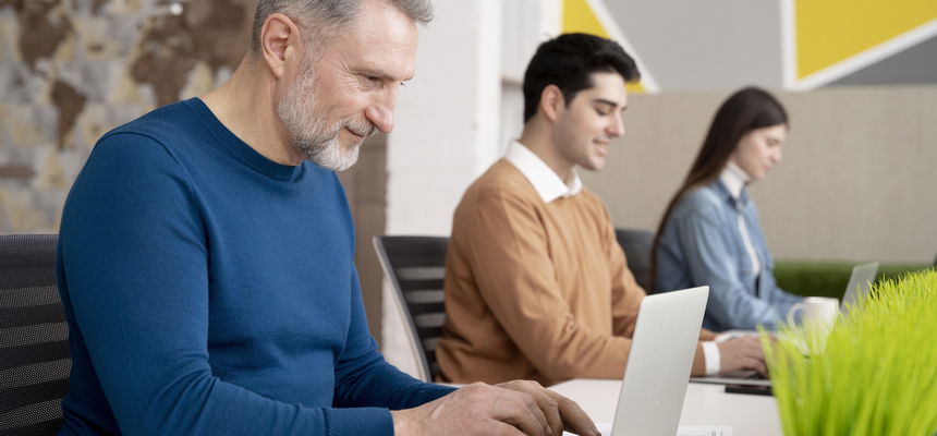 Three people are in front of their laptops.