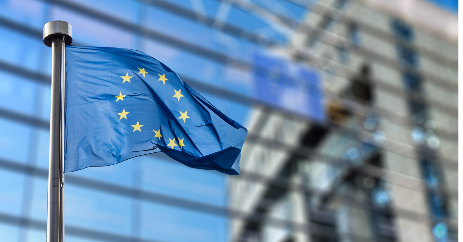 European Union flag waving in front of a modern building.