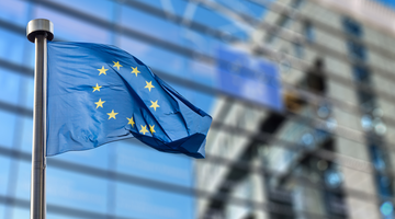 European Union flag waving in front of a modern building.