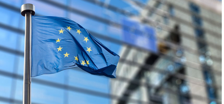 European Union flag waving in front of a modern building.