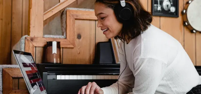 Une femme portant un casque audio utilise un ordinateur portable.