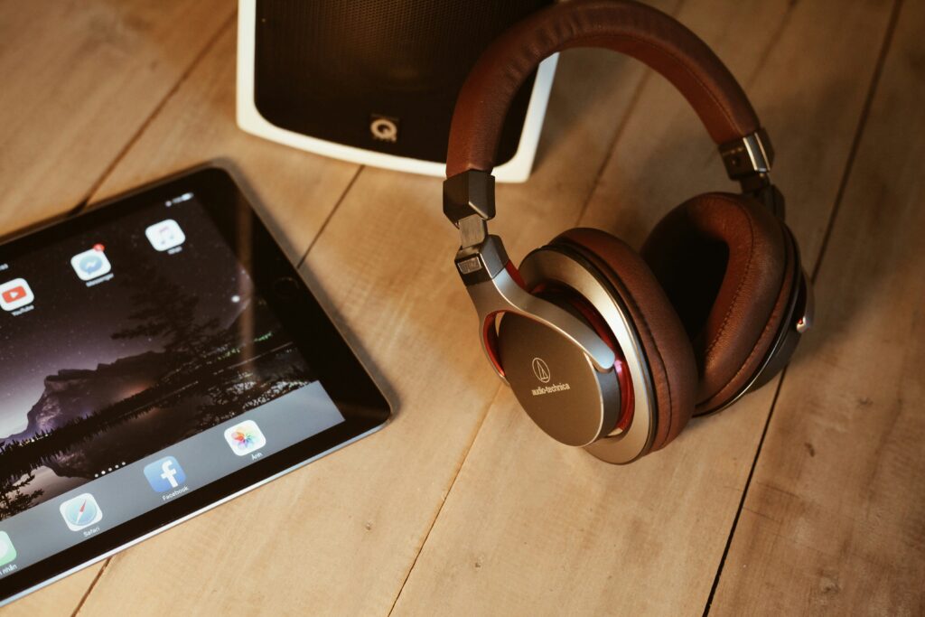 Headphones, tablet and a speaker on a table, representing multi-modal learning.