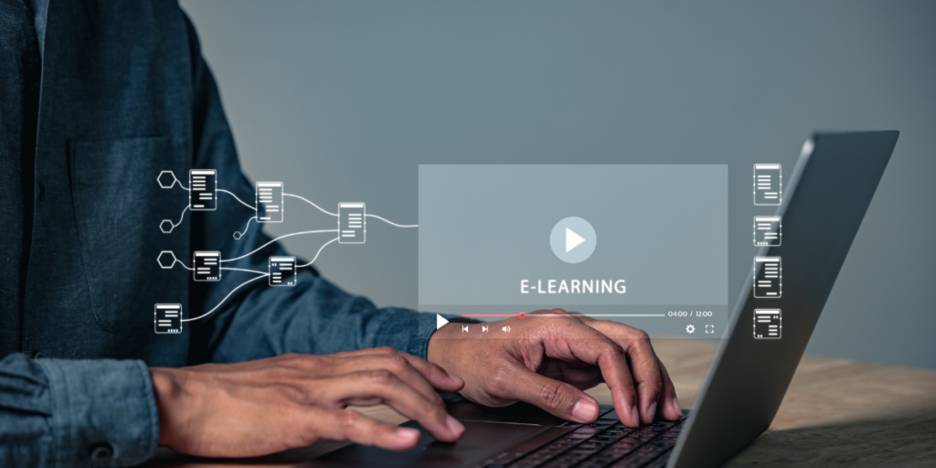 A close-up of hands on a laptop keyboard. Icons are coming out of the laptop next to the word e-learning.