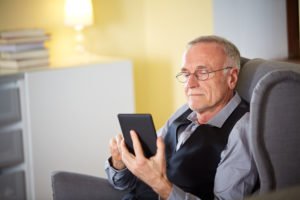 An old man use a tablet