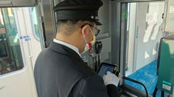 Conductor manages opnboard announcement system on Sanyo Electric Railway