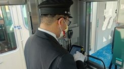 Conductor manages opnboard announcement system on Sanyo Electric Railway