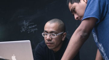 Two higher education students in front of a computer