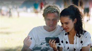 Jongen en meisje die samen naar een video kijken op een smartphone.