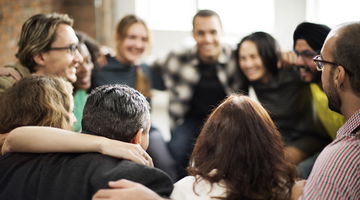 Happy multiethnic team, huddled together talking