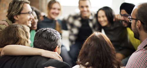 Happy multiethnic team, huddled together talking