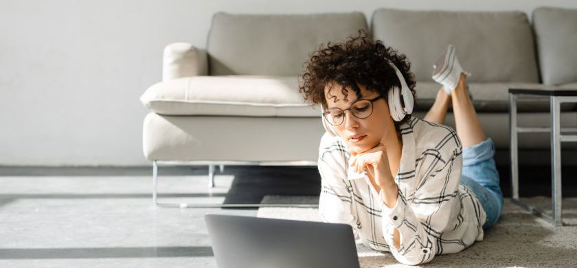 Étudiant portant un casque et écoutant un cours vocalisé sur son ordinateur portable.